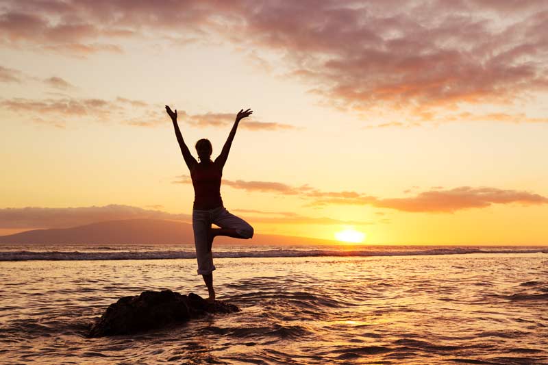 Person practising yoga in front of the sea